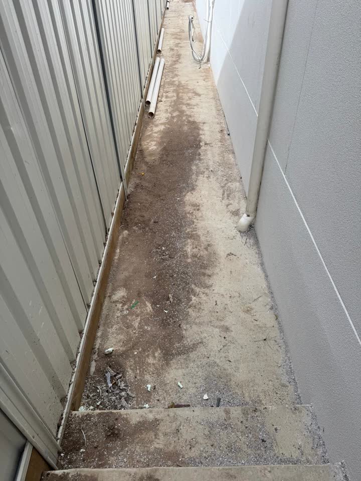 The same side path before, bare and dirty concrete